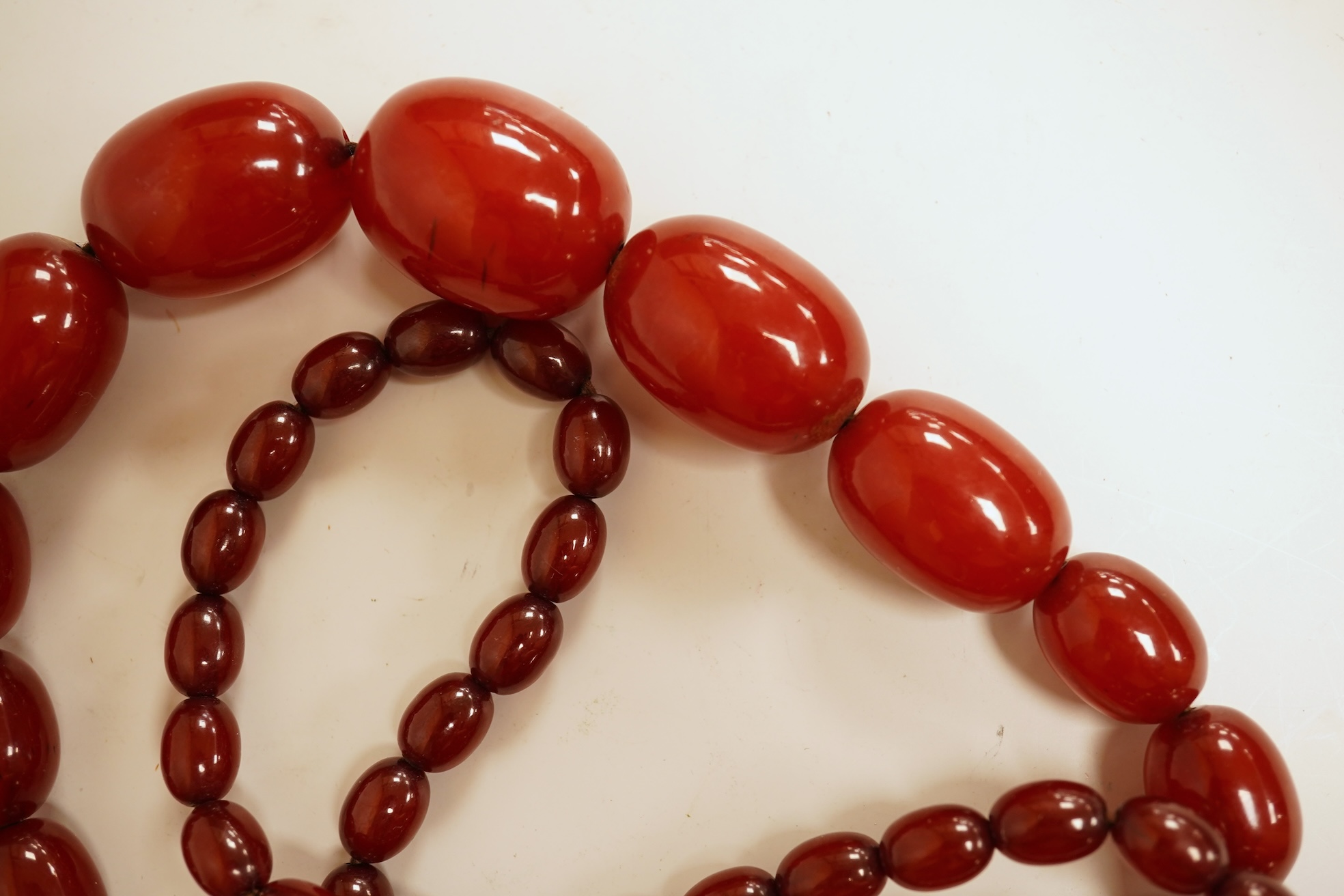 A single strand graduated simulated cherry amber bead necklace, 76cm, gross weight 75 grams.